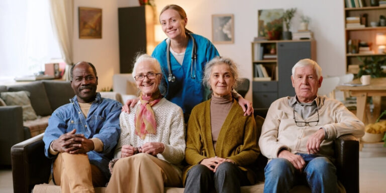 Group of Seniors on Couch with Nurse in Assisted Living Facility
