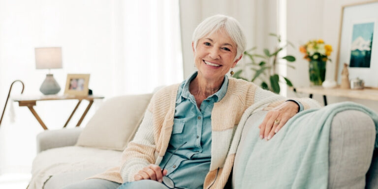 Smiling Elderly Woman Relaxing on Sofa in Bright Living Space Assisted Living Facility