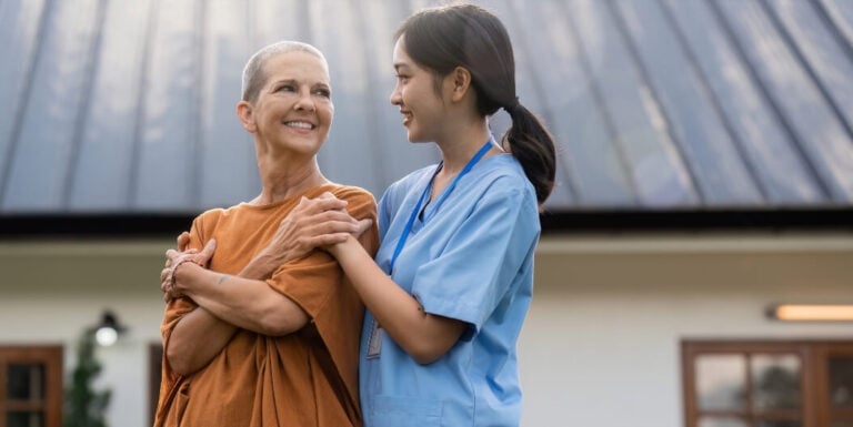 Female Nurse Walking Outdoors with an Elderly Woman at a Memory Care Facility